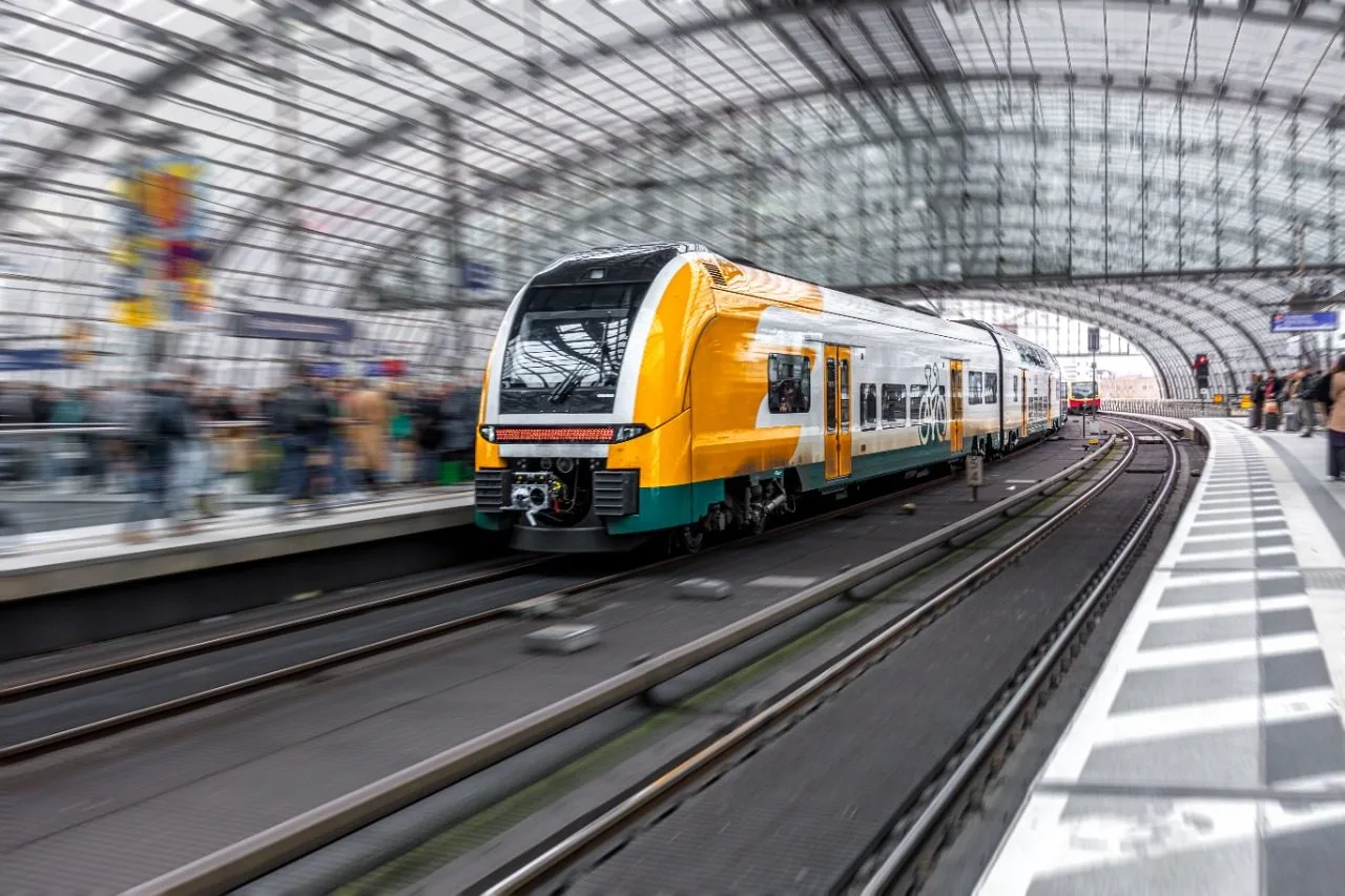 Passenger train arriving at a covered station platform