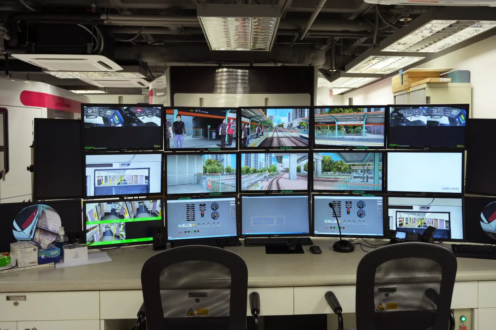 Train driver simulator control room with multi-screen station views