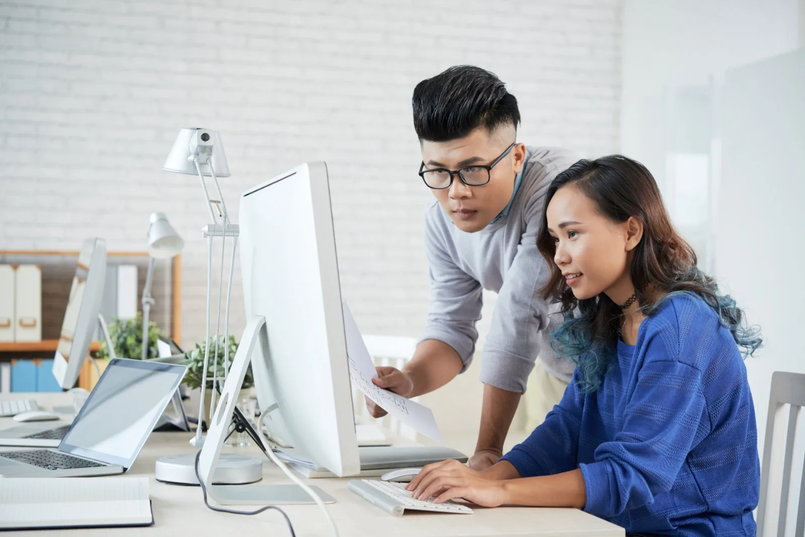 Roctec technical support staff assisting a client at a workstation